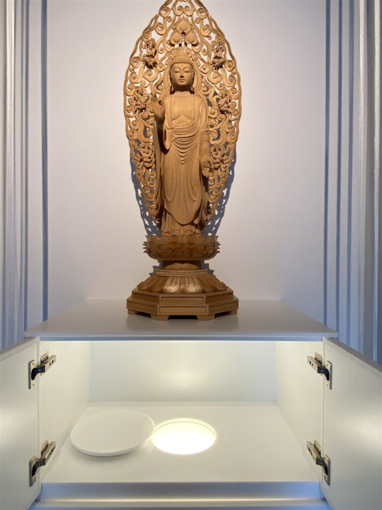 納骨堂amitāの合祀設備。仏像の下に、照明の点いた円形の納骨口
